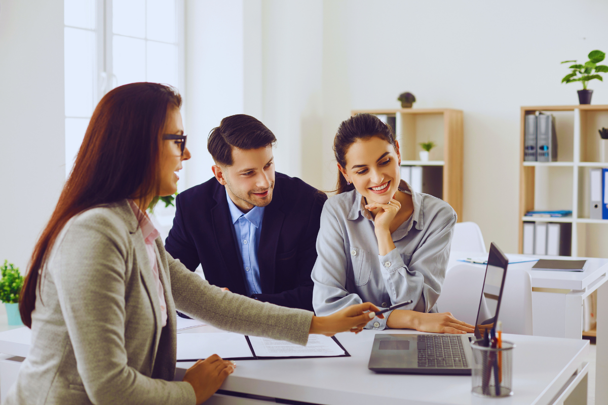 Profissionais do setor de seguros trabalhando em equipe em um escritório moderno, representando diversas funções como corretor, TI e atendimento.