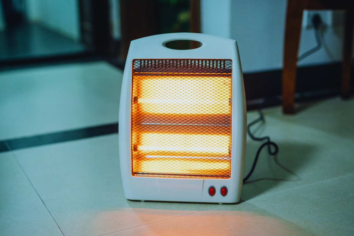 Aquecedor elétrico ligado em ambiente interno durante o inverno, representando conforto e uso consciente de energia.
