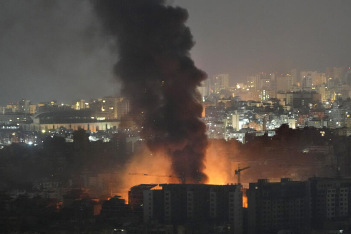 Imagem representando o conflito entre Irã e Israel, com fumaça e cenário de destruição