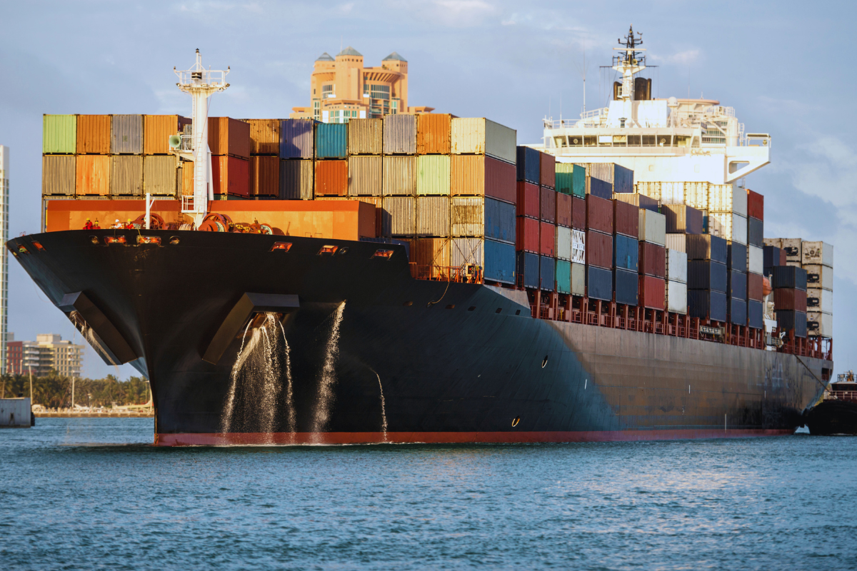 Navio cargueiro com contêineres, representando o impacto do tarifaço dos EUA nas exportações brasileiras e coberturas de seguro.